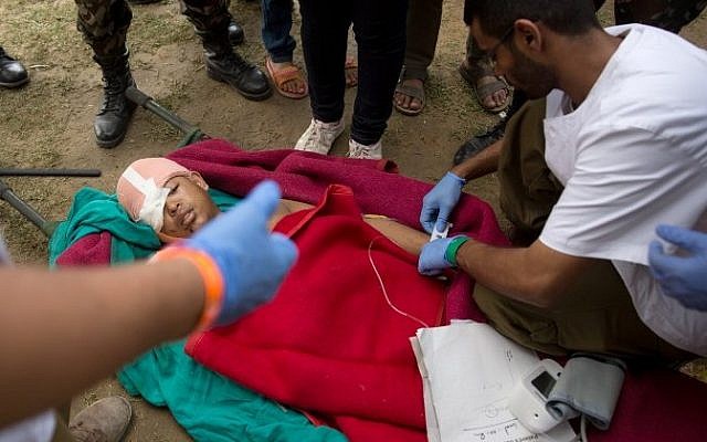An injured Nepalese boy is treated by Israeli Army medic soldiers at the Israeli field hospital on the second day of their mission in Kathmandu on April 29, 2015.(AFP/ MENAHEM KAHANA)
