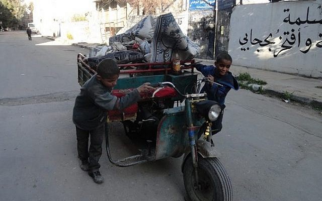 Boys pushing a cart in a street of Yarmouk Palestinian refugee camp, southern Damascus after around 2,000 people were evacuated from the camp after the Islamic State group seized large parts of it, April 4, 2015 (photo credit: AFP / RAMI AL-SAYED) Boys pushing a cart in a street of Yarmouk Palestinian refugee camp, southern Damascus after around 2,000 people were evacuated from the camp after the Islamic State group seized large parts of it, April 4, 2015 (photo credit: AFP / RAMI AL-SAYED)