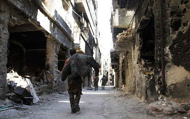 Men walk past destroyed buildings in the Yarmouk Palestinian refugee camp in the Syrian capital Damascus on April 6, 2015. AFP (photo credit:/YOUSSEF KARWASHAN) Men walk past destroyed buildings in the Yarmouk Palestinian refugee camp in the Syrian capital Damascus on April 6, 2015. AFP (photo credit:/YOUSSEF KARWASHAN)