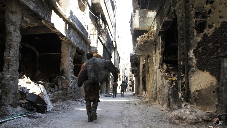 Men walk past destroyed buildings in the Yarmouk Palestinian refugee camp in the Syrian capital Damascus on April 6, 2015. AFP (photo credit:/YOUSSEF KARWASHAN) Men walk past destroyed buildings in the Yarmouk Palestinian refugee camp in the Syrian capital Damascus on April 6, 2015. AFP (photo credit:/YOUSSEF KARWASHAN)