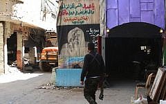 A man walks in a street inside the Yarmouk Palestinian refugee camp in the Syrian capital Damascus on April 6, 2015. (photo credit: AFP/ YOUSSEF KARWASHAN)