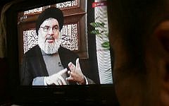 A Syrian watches an interview of Hassan Nasrallah screened on Syria's official television channel Al-Ikhbariya on April 6, 2015 in Damascus. (AFP/STR)