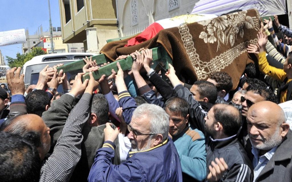 Egyptian relatives and mourners carry the body of police officer Amr Shoukry during his funeral in north Sinai's provincial capital of Al-Arish on April 13, 2015, after he was killed in a bomb attack targeting the Al-Arish police station the previous day. (photo credit: AFP/STR)