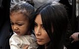 US reality TV star Kim Kardashian carries her daughter, North West, upon arrival at the Armenian St. James Cathedral in Jerusalem's Old City on April 13, 2015. (AFP/Ahmad Gharabli)