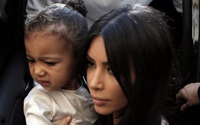 US reality TV star Kim Kardashian carries her daughter, North West, upon arrival at the Armenian St. James Cathedral in Jerusalem's Old City on April 13, 2015. (AFP/Ahmad Gharabli)