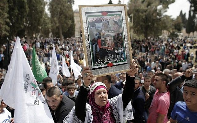 A Palestinian woman holds a portrait of a prisoner during a rally marking Palestinian Prisoners Day outside the Dome of the Rock at the Al-Aqsa mosque compound in Jerusalem's Old City, on April 17, 2015. (Photo credit: AFP / AHMAD GHARABLI) A Palestinian woman holds a portrait of a prisoner during a rally marking Palestinian Prisoners Day outside the Dome of the Rock at the Al-Aqsa mosque compound in Jerusalem's Old City, on April 17, 2015. (Photo credit: AFP / AHMAD GHARABLI)