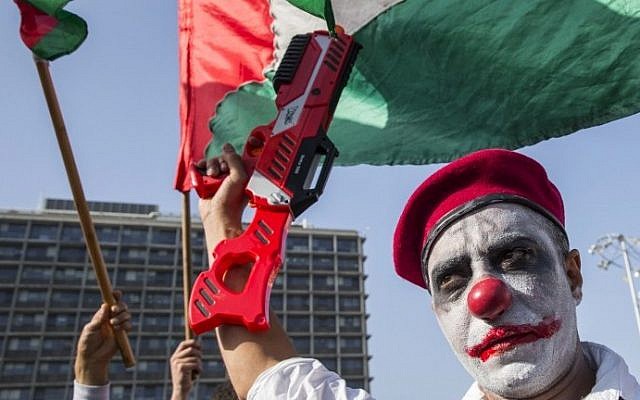 An Arab Israeli man, with his face painted, holds a plastic gun during a rally against the demolition of Arab homes across the country at Rabin Square in Tel Aviv on April 28, 2015. photo credit: AFP PHOTO / JACK GUEZ)