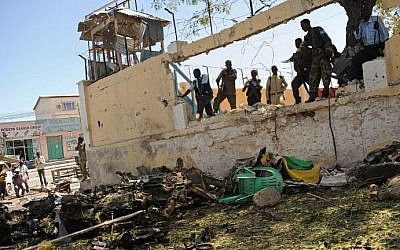 Somali security services survey the scene of a car bomb outside the Education Ministry in Mogadishu on April 14, 2015. (photo credit: AFP/Mohammed Abdiwahab)