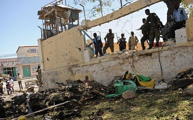 Somali security services survey the scene of a car bomb outside the Education Ministry in Mogadishu on April 14, 2015. (photo credit: AFP/Mohammed Abdiwahab) Somali security services survey the scene of a car bomb outside the Education Ministry in Mogadishu on April 14, 2015. (photo credit: AFP/Mohammed Abdiwahab)
