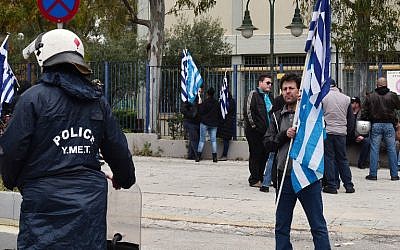 Police cordon off Golden Dawn party supporters carrying Greek flags, outside the high security prison in Korydallos near Athens on April 20, 2015. (photo credit: AFP) 