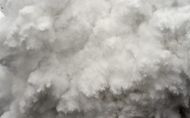 A cloud of snow and debris triggered by an earthquake flies towards Everest Base Camp, moments ahead of flattening part of the camp in the Himalayas, April 25, 2015. (photo credit: AFP/ROBERTO SCHMIDT) 