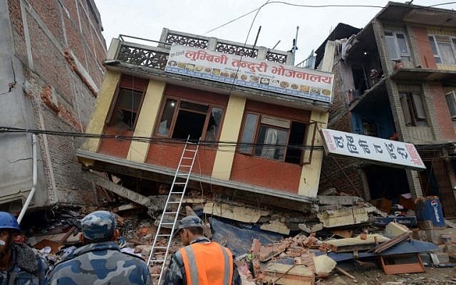 Nepalese rescue personnel observe damaged buildings following an earthquake in Kathmandu on April 26, 2015. (photo credit: AFP/PRAKASH MATHEMA)