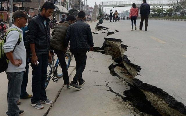 Nepalese residents walk past road damage after an earthquake in Kathmandu, Nepal, on April 26, 2015. (photo credit: AFP/Prakash Mathema) Nepalese residents walk past road damage after an earthquake in Kathmandu, Nepal, on April 26, 2015. (photo credit: AFP/Prakash Mathema)
