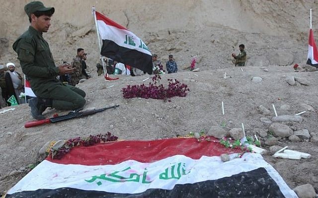 An Iraqi Shiite fighter prays at a burial site believed to hold victims of a June 2014 massacre in which hundreds of army cadets were executed by the Islamic State group, in the city of Tikrit, on April 4, 2015. (AFP/AHMAD AL-RUBAYE) An Iraqi Shiite fighter prays at a burial site believed to hold victims of a June 2014 massacre in which hundreds of army cadets were executed by the Islamic State group, in the city of Tikrit, on April 4, 2015. (AFP/AHMAD AL-RUBAYE)