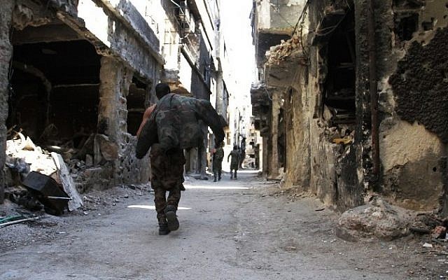 Men walk past destroyed buildings in the Yarmouk Palestinian refugee camp in the Syrian capital Damascus on April 6, 2015. (AFP/ YOUSSEF KARWASHAN) Men walk past destroyed buildings in the Yarmouk Palestinian refugee camp in the Syrian capital Damascus on April 6, 2015. (AFP/ YOUSSEF KARWASHAN)