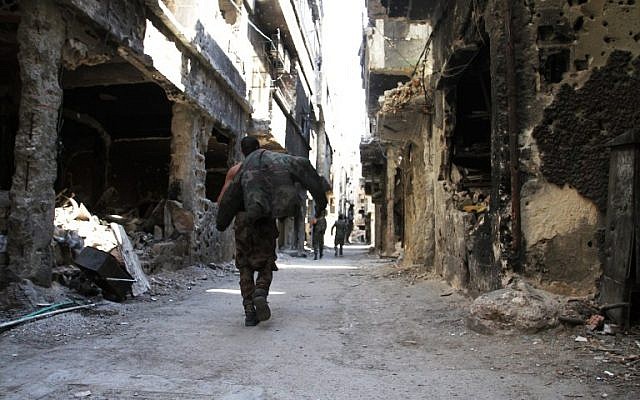 Men walk past destroyed buildings in the Yarmouk Palestinian refugee camp in the Syrian capital Damascus on April 6, 2015. (AFP/Youssef Karwashan) Men walk past destroyed buildings in the Yarmouk Palestinian refugee camp in the Syrian capital Damascus on April 6, 2015. (AFP/Youssef Karwashan)