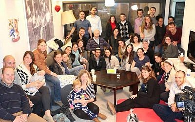 Young people gather to hear testimony from Holocaust survivor Tzvi Ben Porat (second from left, second row from back) at 'Zikaron Basalon' event at Malhi family home in Jerusalem, April 15, 2015. (photo credit: Noam Feiner)