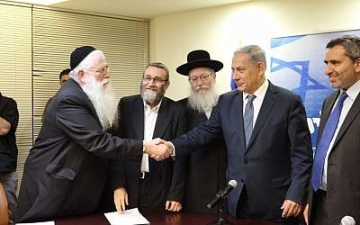 Prime Minister Benjamin Netanyahu shakes hands with UTJ's Meir Porush in the Knesset, on April 29, 2015, after the two parties signed a coalition agreement. To Netanyahu's right is UTJ leader Yaakov Litzman. (Courtesy, Likud Party)