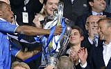Chelsea's owner Roman Abramovich (right) applauds as striker Didier Drogba holds up the Champions League trophy, May 19, 2012. (AP Photo/Martin Meissner)