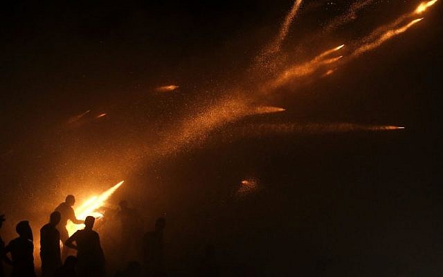 A man ignites rockets during Greek Orthodox Easter celebrations on the eastern Aegean island of Chios, April 11, 2015. (photo credit: AP/ Petros Giannakouris)