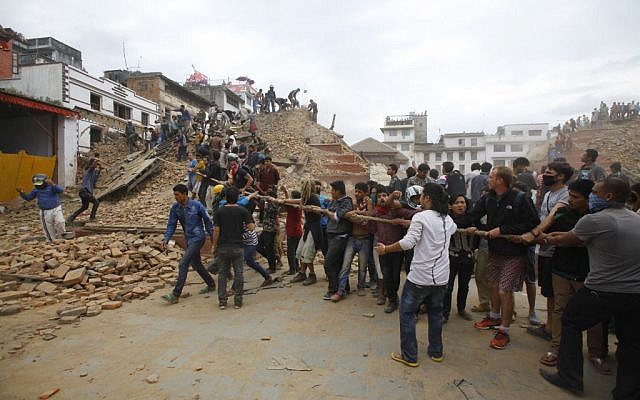 Volunteers help remove debris of a building that collapsed at Durbar Square, after an earthquake in Kathmandu, Nepal, Saturday, April 25, 2015. (photo credit: AP/Niranjan Shrestha)