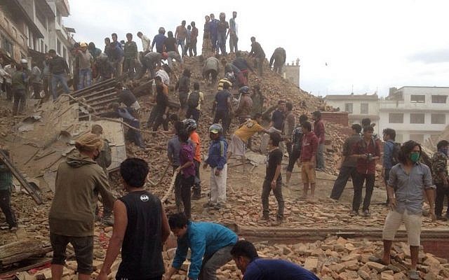 Volunteers help with rescue work at the site of a building that collapsed after an earthquake in Kathmandu, Nepal, Saturday, April 25, 2015. (Photo credit: AP/ Niranjan Shrestha)