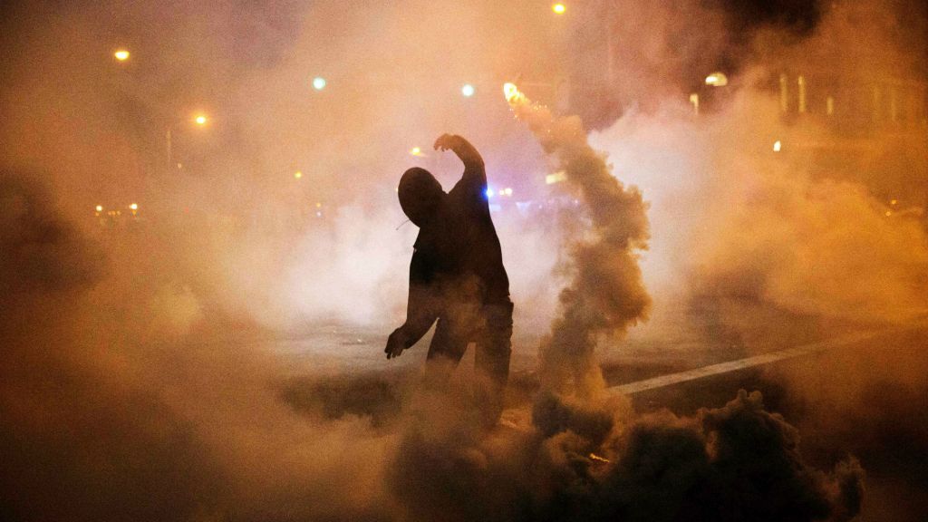 A protester throws a tear gas canister back toward riot police after a 10 p.m. curfew went into effect in the wake of Monday's riots following the funeral for Freddie Gray, Tuesday, April 28, 2015, in Baltimore. (AP Photo/David Goldman) A protester throws a tear gas canister back toward riot police after a 10 p.m. curfew went into effect in the wake of Monday's riots following the funeral for Freddie Gray, Tuesday, April 28, 2015, in Baltimore. (AP Photo/David Goldman)