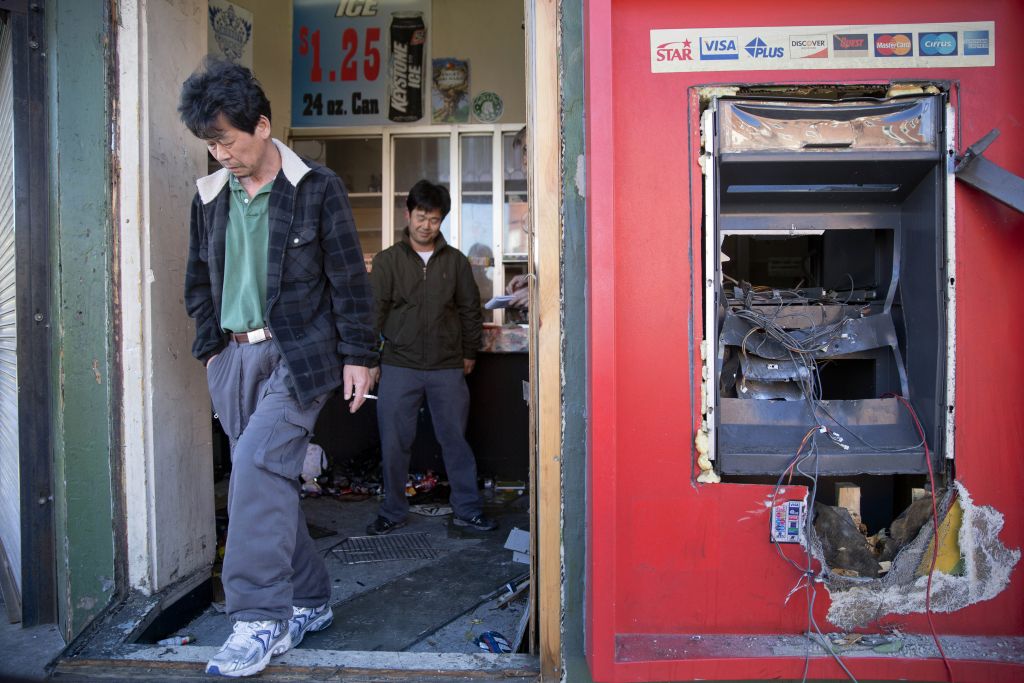 Jason Park, left, and his friend business owner Sung Kang, second left, leave his damaged store, Tuesday, April 28, 2015, in the aftermath of rioting following Monday's funeral for Freddie Gray, who died in police custody. (photo credit: AP Photo/Matt Rourke) Jason Park, left, and his friend business owner Sung Kang, second left, leave his damaged store, Tuesday, April 28, 2015, in the aftermath of rioting following Monday's funeral for Freddie Gray, who died in police custody. (photo credit: AP Photo/Matt Rourke)