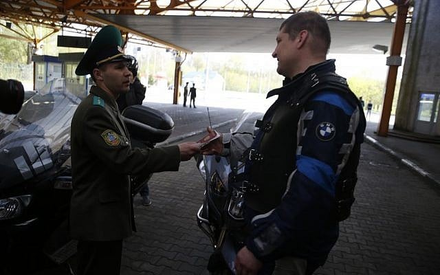 Belarus border guard checks the passport of a Russian biker at the Brest checkpoint on the Belarus-Polish border, April 27, 2015. (photo credit: AP/Sergei Grits) Belarus border guard checks the passport of a Russian biker at the Brest checkpoint on the Belarus-Polish border, April 27, 2015. (photo credit: AP/Sergei Grits)