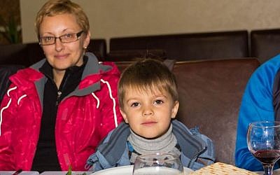  Margarita Artyunyan and her four-year-old son Vadim, Jewish refugees from the Ukrainian city of Donetsk, during a simulated 'seder' meal at The Jewish Agency's refugee center outside Dnepropetrovsk ahead of their immigration to Israel, March 29, 2015. (photo credit: The Jewish Agency/Vlad Tomilov)