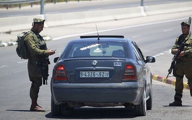 Israeli soldiers check Palestinian cars at the Gush Etzion Intersection in the West Bank, June 15, 2014. (photo credit: Hadas Parush/Flash90) Israeli soldiers check Palestinian cars at the Gush Etzion Intersection in the West Bank, June 15, 2014. (photo credit: Hadas Parush/Flash90)