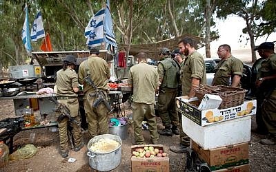 IDF reserve soldiers seen getting food in a staging area near the border with Gaza in southern Israel on July 20, 2014, during Israel's Operation Protective Edge. (Moshe Shai/Flash90)