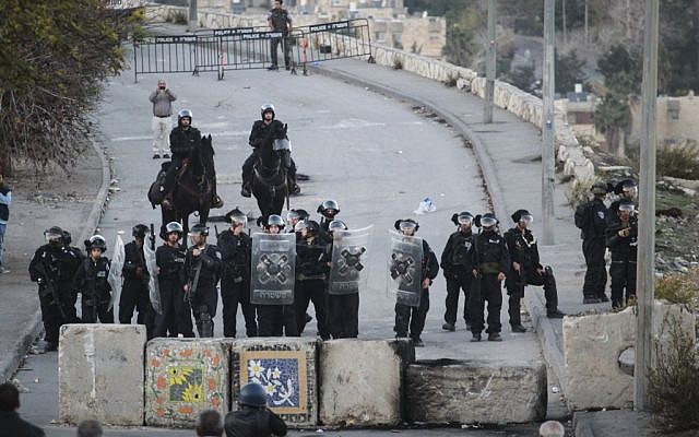 Israeli Border Police stand guard next to new cement blocks placed at the entrance to Issawiya in East Jerusalem during a demonstration against the neighborhood's closure, November 12, 2014 (photo credit: Hadas Parush/Flash90) Israeli Border Police stand guard next to new cement blocks placed at the entrance to Issawiya in East Jerusalem during a demonstration against the neighborhood's closure, November 12, 2014 (photo credit: Hadas Parush/Flash90)