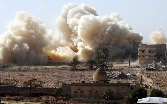Smoke rises after a house was blown up during a military operation by Egyptian security forces in the Egyptian city of Rafah near the border with southern Gaza Strip on November 20, 2014 (photo credit: Abed Rahim Khatib/Flash90)
