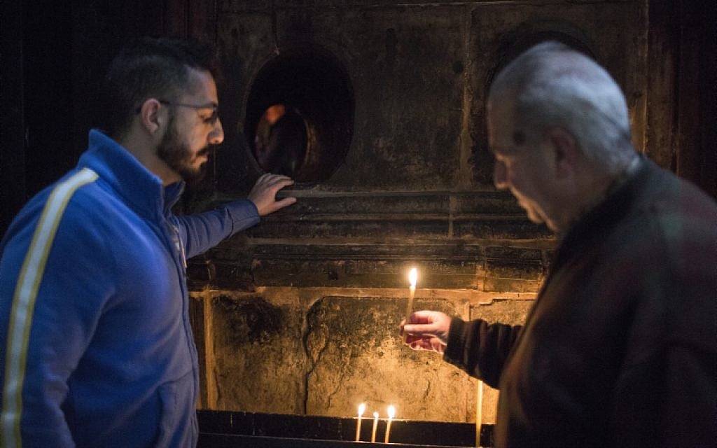 Soghomon Toumayan (R) and his son Michael (L), talk as they stand by the hole to the Chamber of the Tomb of Christ at the Church of the Holy Sepulchre in Jerusalem's Old City, on April 15, 2015.  (photo credit: Hadas Parush/Flash90)