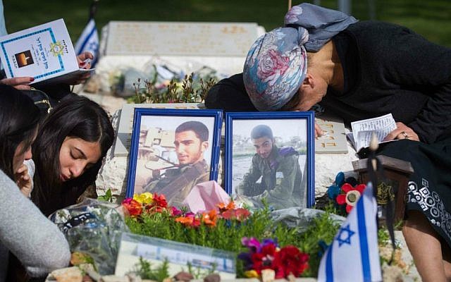 Bereaved Israelis mourn next to the graves of fallen soldiers at the Mt. Herzl military cemetery in Jerusalem, April 22, 2015. (Miriam Alster/Flash90)