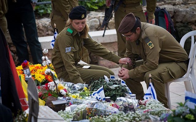 Israeli soldiers mourn next to the graves of fallen soldiers at the Mt. Herzl military cemetery in Jerusalem, April 22, 2015. (Miriam Alster/Flash90)