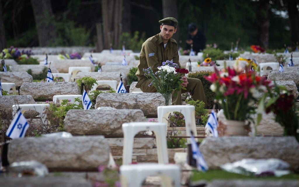 Israeli soldiers mourn next to graves of fallen soldiers at the Mt. Herzl military cemetery in Jerusalem, during Israeli Memorial Day on April 22, 2015. (photo credit: Miriam Alster/Flash90)