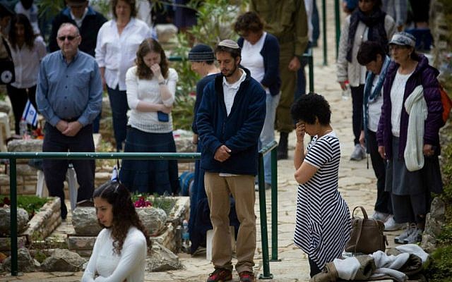Israelis stand in silence next to the graves of IDF soldiers at the Mt. Herzl military cemetery in Jerusalem, April 22, 2015. (Miriam Alster/Flash90)