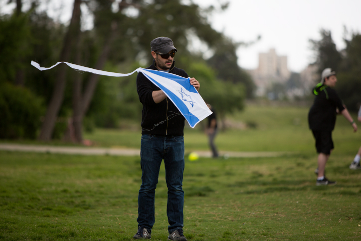An Israeli man prepares to fly a kite decorated with the Israeli flag during the Independece Day celebrations in a Jerusalem park on April 23, 2015. (Photo credit: Yonatan Sindel/Flash90) An Israeli man prepares to fly a kite decorated with the Israeli flag during the Independece Day celebrations in a Jerusalem park on April 23, 2015. (Photo credit: Yonatan Sindel/Flash90)