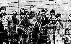A picture taken just after the liberation by the Soviet army in January 1945 shows a group of children wearing concentration camp uniforms behind barbed wire fencing in the Auschwitz Nazi concentration camp. (AP Photo/File)