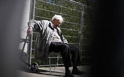 File: ormer SS guard Oskar Groening sits behind a fence during a break in the trial against him in Lueneburg, northern Germany, Tuesday, April 21, 2015. (Photo credit: Markus Schreiber/AP) 