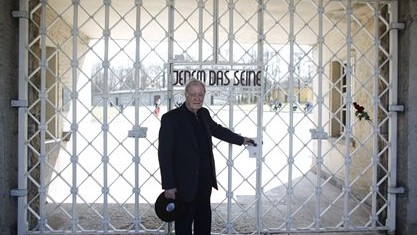 Henry Oster poses at the gate of the former Nazi concentration camp Buchenwald with the inscription 'Jedem das Seine' (To each his own), April 10, 2015 (Photo credit: Markus Schreiber/AP) Henry Oster poses at the gate of the former Nazi concentration camp Buchenwald with the inscription 'Jedem das Seine' (To each his own), April 10, 2015 (Photo credit: Markus Schreiber/AP)