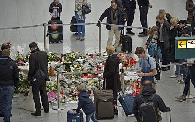 Passengers watch candles and flowers for the victims of the plane crash at the airport in Dusseldorf , Germany, Tuesday, March 31, 2015. (photo credit: AP/Martin Meissner)