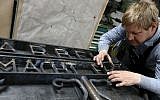 Blacksmith Michael Poitner works on a replica of the Dachau Nazi concentration camp gate with the writing "Arbeit macht frei" (Work Sets you Free) in Biberbach near Dachau, Germany, Thursday, April 16, 2015. The original gate was stolen in November 2014. (Photo credit: AP/Matthias Schrader)