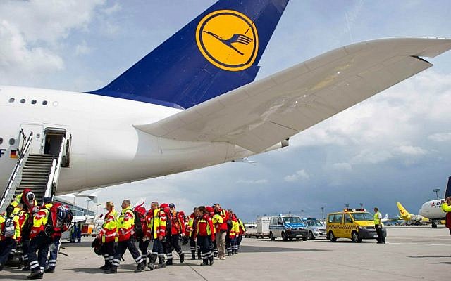 Members of a German rescue organization board a plane at the airport in Frankfurt, central Germany, Sunday, April 26, 2015, for their flight to earthquake-torn Nepal. (Christoph Schmidt/dpa via AP)