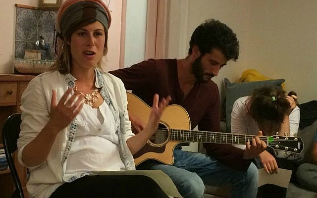 Sasha Leshem (left) leads singing and Jonah Clarfield play guitar at 'Zikaron Basalon' gathering in Jerusalem, April 15, 2015. (photo credit: Renee Ghert-Zand/Times of Israel staff)