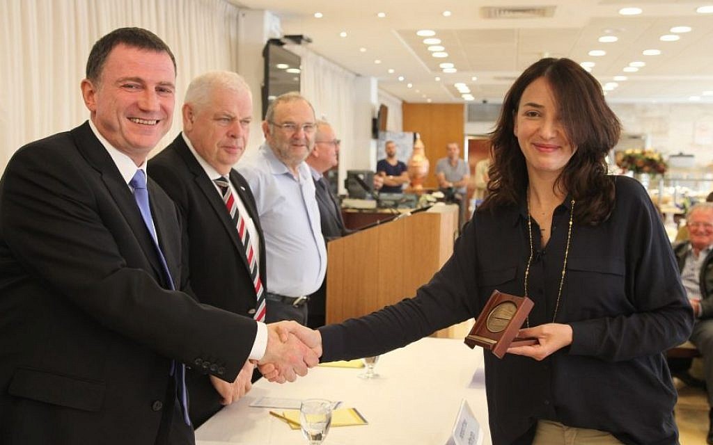 Lucy Aharish, journalist, news anchor and actress, receives a medal from Knesset Speaker Yuli Edelstein on Monday, April 20, 2015. (Photo credit: Knesset)