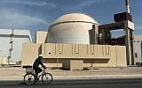A worker rides a bicycle in front of the reactor building of the Bushehr nuclear power plant, just outside the southern city of Bushehr, Iran, on October 26, 2010. (AP/Mehr News Agency, Majid Asgaripour, File)