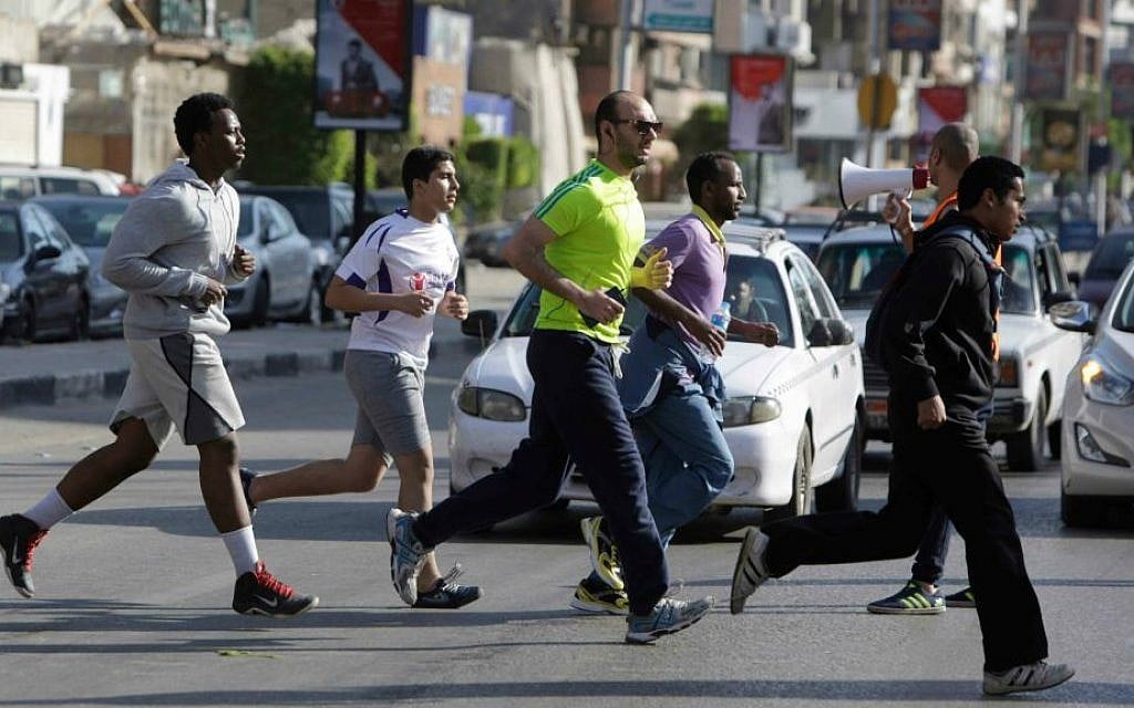 In this Friday, April 10, 2015 picture, Egyptian runners cross a street in the Mohandiseen district in Cairo, Egypt. (AP Photo/Amr Nabil)